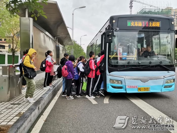 学生在公交站台上车。